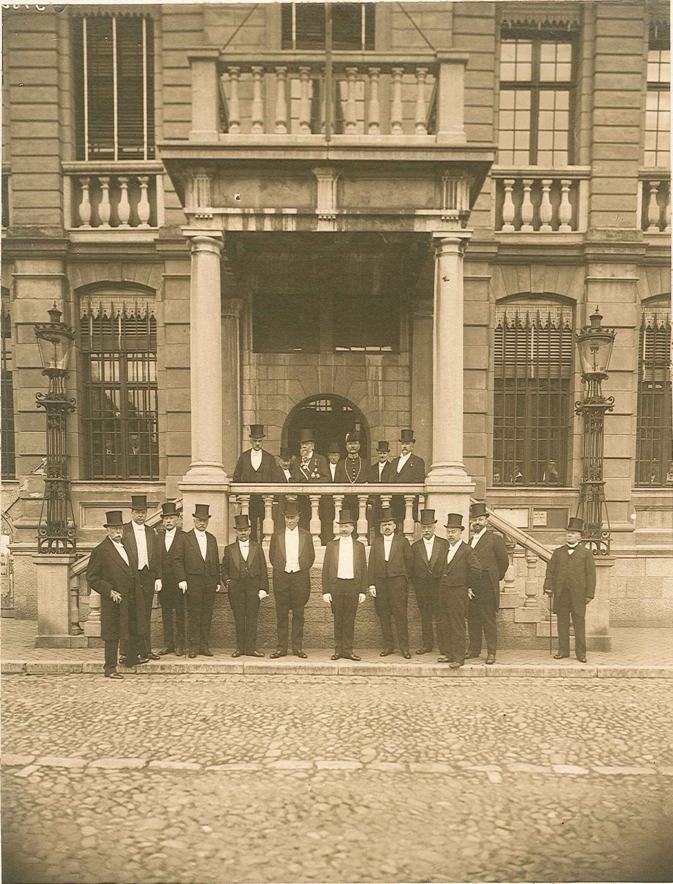 Foto van de 90-jarige Dr. P. Cuypers staande op het bordes vóór het stadhuis van Roermond.