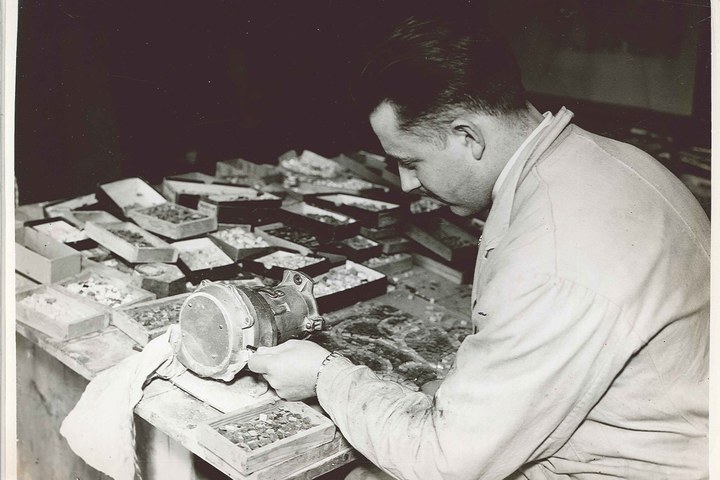 Foto uit de Cuypers' Kunstwerkplaatsen van rond 1930: Dhr. Piet Peeters bezig met het slijpen van mozaïeksteentjes.