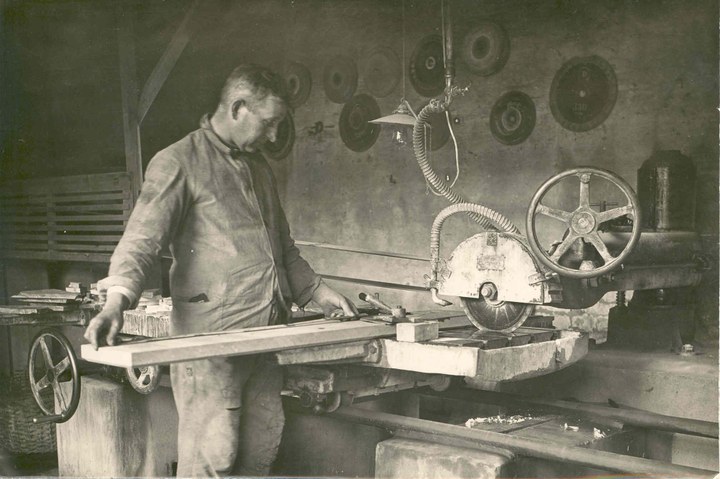 Foto van H. Suiker aan de electrische steenzaag in de kunstwerkplaatsen van Cuypers