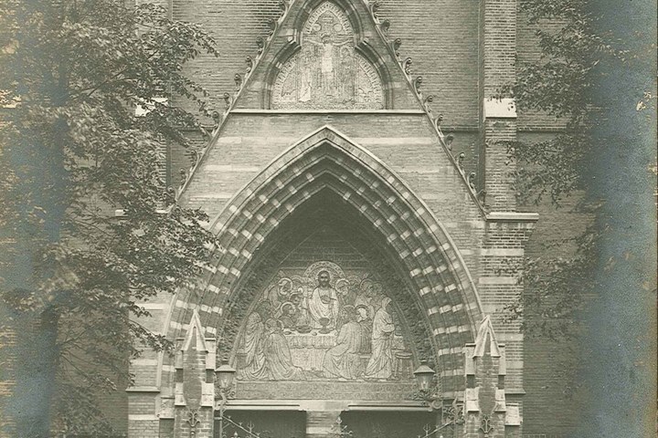 Foto van twee mozaïekpanelen boven een kerkpoort te Amsterdam.