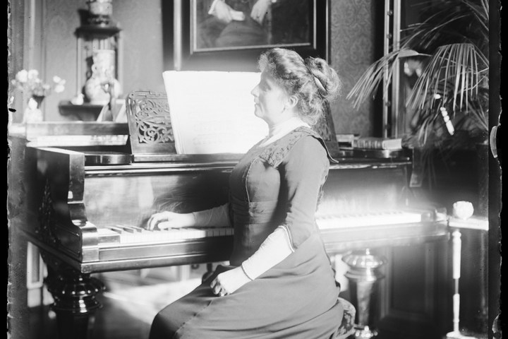 Glasnegatief van Delphine Povel achter piano