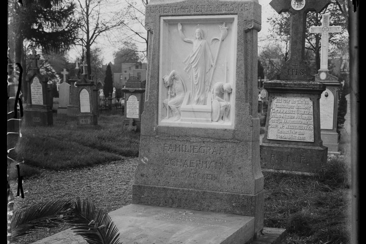 Glasnegatief van foto van producten uit de Cuypers' Kunstwerkplaatsen: "Foto van een grafmonument met meerdere graven op de achtergrond".