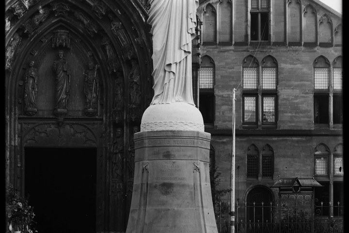 Glasnegatief van foto van producten uit de Cuypers' Kunstwerkplaatsen: "Foto van een Heilig Hartbeeld vóór een kerkgebouw".