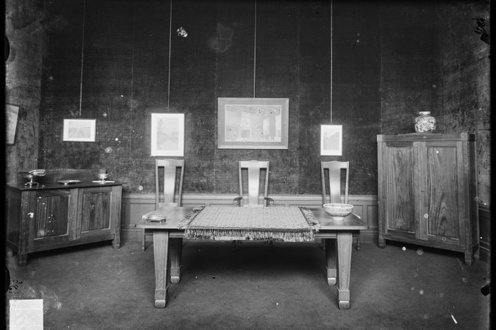 Glasnegatief van foto van producten uit de Cuypers' Kunstwerkplaatsen: "Foto van een interieur met een lage tafel, twee kasten en drie stoelen".